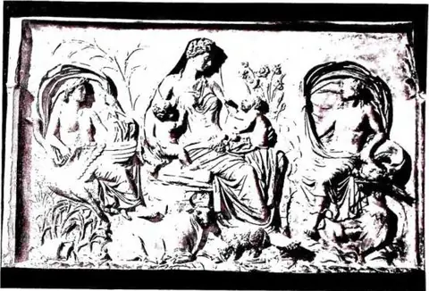 Above: PERSONIFICATION OF 'TELLUS' between Air and Water. Detail of the reliefs of the Ara Pacis (9 BC) - Rome. Below: PERSONIFICATION OF 'EARTH'. Miniature of the Exultet I (ca. 1000) - Bari, Cathedral.
